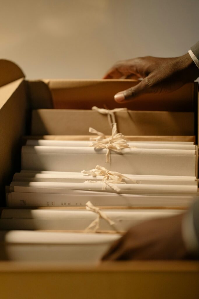 Close-up of hands organizing files in a box, emphasizing confidentiality and organization.